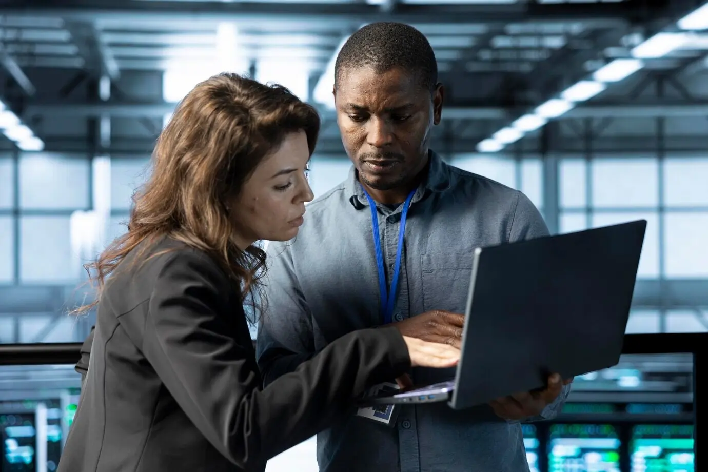 ИТ-специалисты в серверном хабе разговаривают, используя ноутбук для настройки параметров питания.