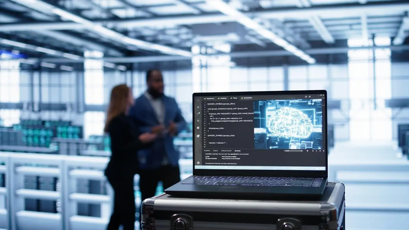 Ноутбук в помещении дата-центра с симуляцией искусственного интеллекта.